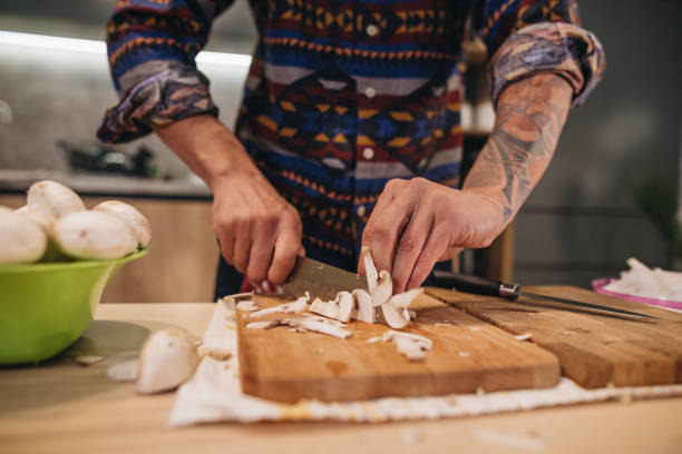 istock Chef cutting mushrooms on a cutting board 1166458238