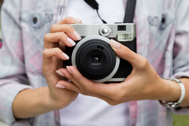 istock Young woman holding in hands old vintage camera 1166461740