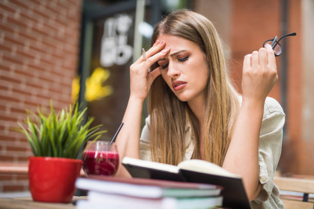 istock Young woman having a headache from studying. 1166461814
