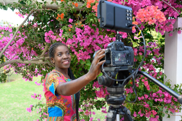 istock Young African Woman Setting up Camera for Video Blog 1166463739