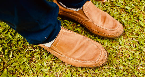 istock Man in a leather made shoes on a grassy ground 1166464048