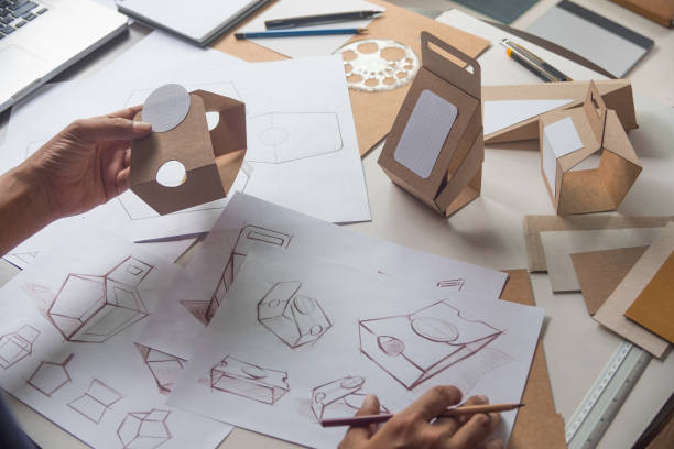 istock Designer sketching drawing design Brown craft cardboard paper product eco packaging mockup box development template package branding Label . designer studio concept . 1166464306