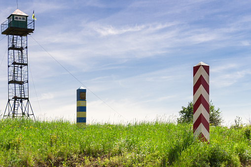Eastern border of the European Union. Part of the Polish-Ukrainian border. Polish and Ukrainian border pillars. Ukrainian observation tower in the background