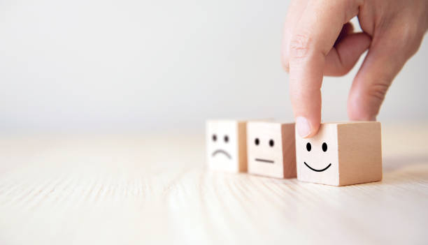 istock Close up customer hand choose smiley face on wood cube, Service rating, satisfaction concept. 1166467517