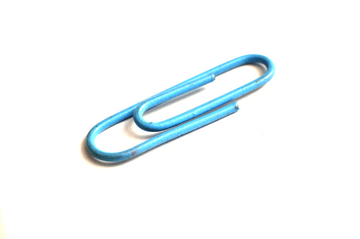 Paper clips, made of iron, are curved in a white background, useful for paper clips\