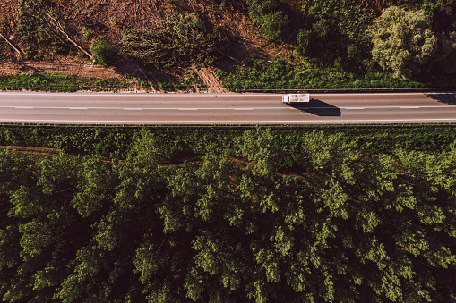 Vista aérea del camión en carretera a través del paisaje forestal photo