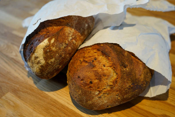 istock Freshly baked bread in a paper bag on a wooden table 1166474416