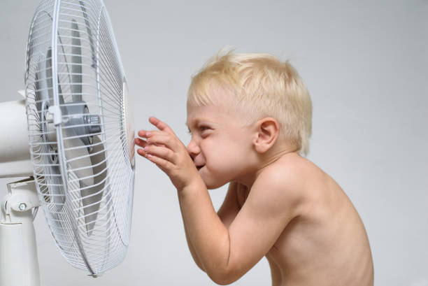 istock Little blond boy with naked torso touch the ventilator. Summer concept 1166476183
