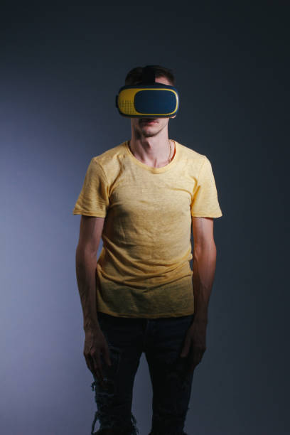 istock technology, gaming, entertainment and people concept - young man with virtual reality headset or 3d glasses. Studio shot, gray background. 1166477084