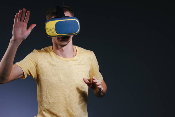 istock technology, gaming, entertainment and people concept - young man with virtual reality headset or 3d glasses. Studio shot, gray background. 1166477157