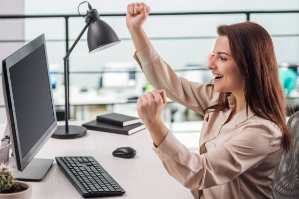 istock happy young woman rejoicing at workplace in modern office 1166478623