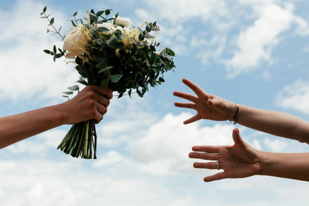 istock bridal bouquet in the sky with hands trying to catch it 1166480108