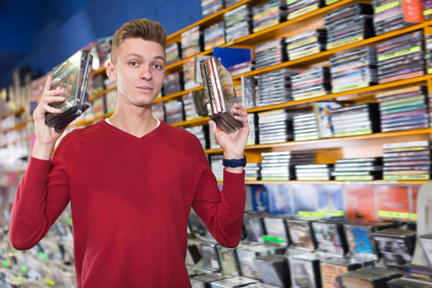istock Modern man choosing movies on DVD at store 1166480748