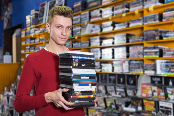 istock guy holding pile of boxes with DVDs 1166480760