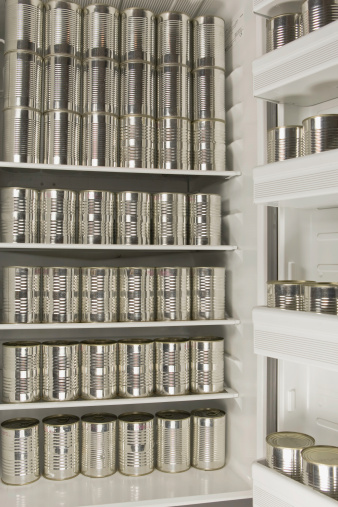 Unlabelled cans of foodstuff in a refrigerator.