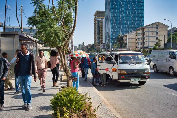 Crowd in bus station in Addis Ababa, Ethiopia Addis Ababa, Ethiopia - December 20, 2018: Crowd of local people in a bus station in Addis Ababa, Ethiopia, with some people waiting and other getting into a car used as a bus. ethiopia city stock pictures, royalty-free photos & images