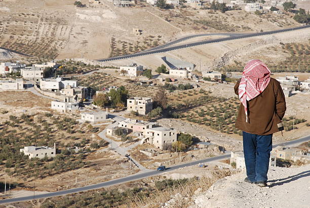 Solitary Man in Palestine A Palestinian stands above a village on the outskirts of the West Bank town of Bethlehem. palestinian territories stock pictures, royalty-free photos & images