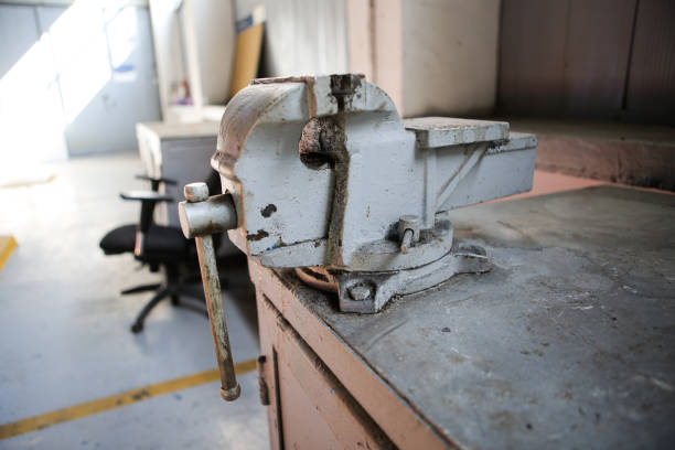 istock Shallow depth of field image with a rusty and dirty heavy iron vice on a workbench inside a workshop with no people around 1166485125