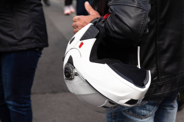 istock a man in a black leather jacket holds a white motorcycle helmet. close-up 1166486499