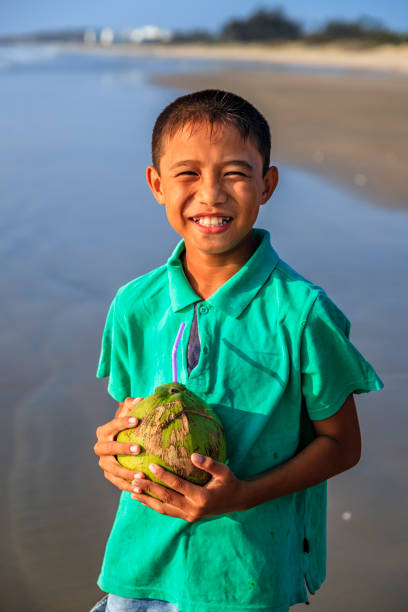istock Vietnamese boy holding coconuts on the beach, Vietnam 1166486711