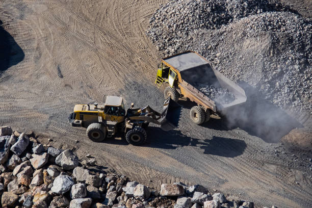 istock Excavator loading dumper truck on mining site stock photo 1166488451