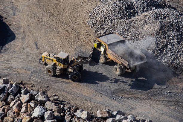 istock Excavator loading dumper truck on mining site stock photo 1166488785