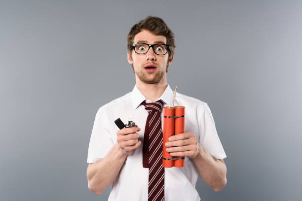shocked businessman holding lighter and dynamite on grey background