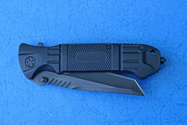 istock big black folding knife lies on a blue table 1166496984