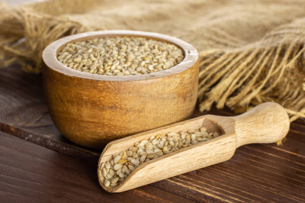 istock Unpeeled sesame seeds on brown wood 1166497125