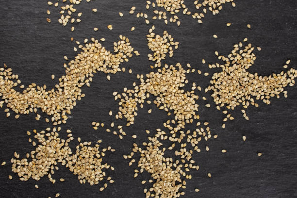 Unpeeled sesame seeds on grey stone