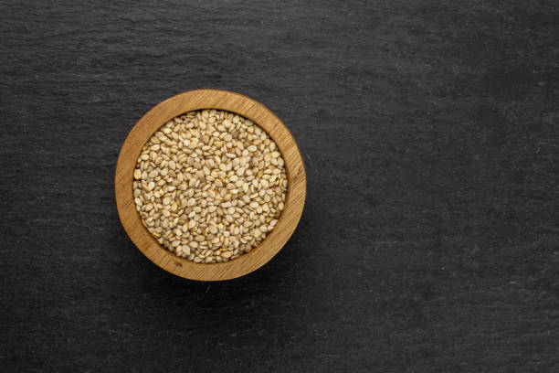 Unpeeled sesame seeds on grey stone