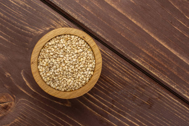 istock Unpeeled sesame seeds on brown wood 1166497154
