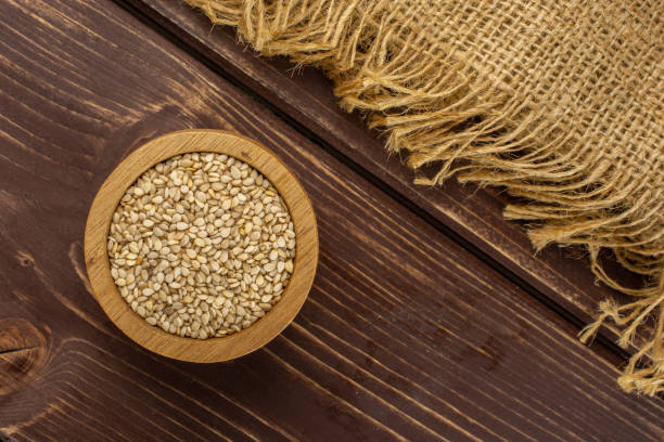istock Unpeeled sesame seeds on brown wood 1166497157