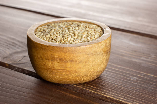 istock Unpeeled sesame seeds on brown wood 1166497182