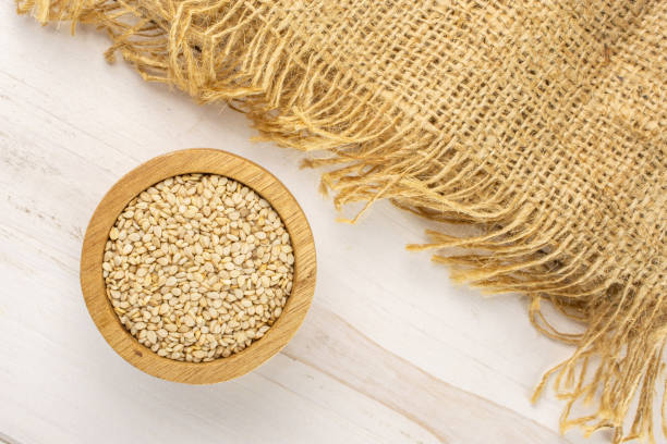Unpeeled sesame seeds on grey wood
