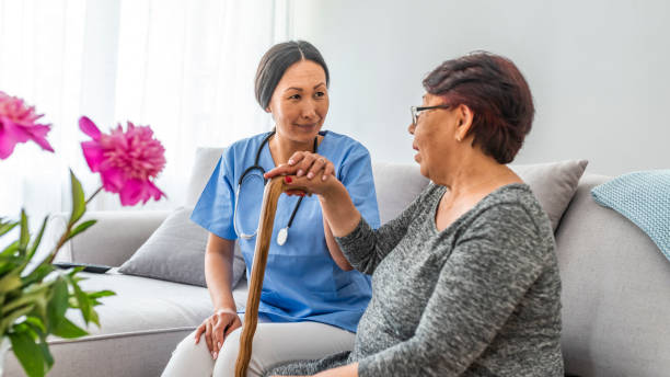 istock Woman with walking stick assisted by young carer. 1166498559