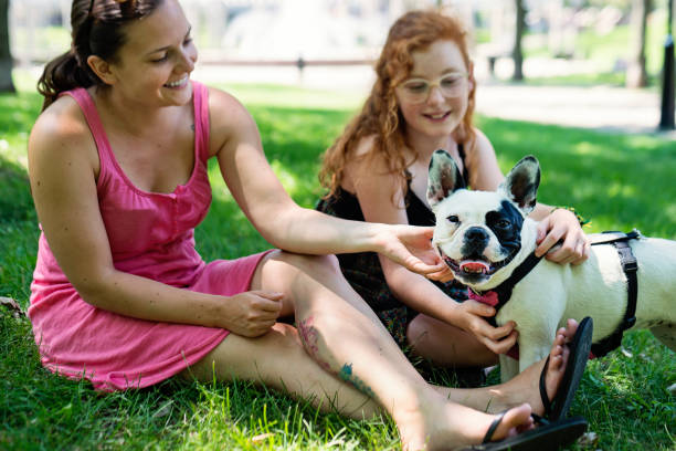 istock Two girls in a park with a dog 1166498671