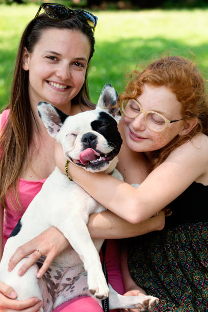 istock Two girls in a park with a dog 1166498740