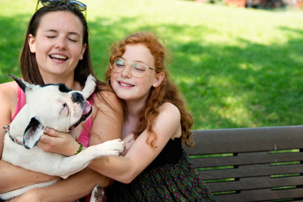 istock Two girls in a park with a dog 1166498856