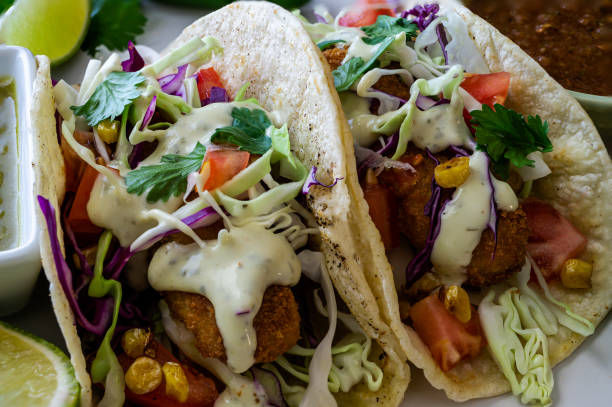 istock Oven-fried fish tacos with cabbage tomatoes, roasted corn and avocado-cilandro sauce 1166499556