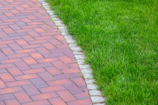 istock red tile walkway with stone curb and green lawn. 1166501601