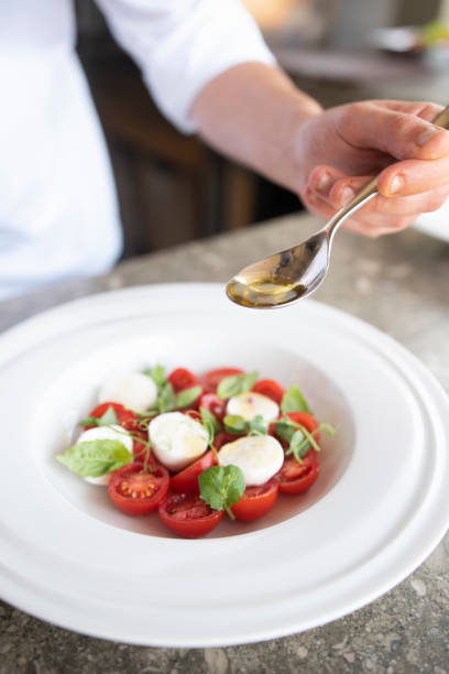 istock Male cook adding details to a salad 1166502292
