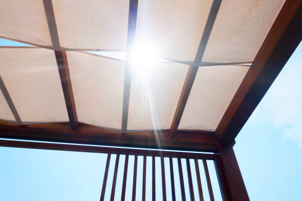 Canopy with Fabric roof in the form of a beige tent. Fabric roof in the form of a beige tent.Canopy from wooden levels against the sky. patio cover stock pictures, royalty-free photos & images