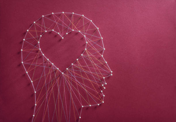 Developing emotional intelligence concept Learning to love concept. Network of pins and threads in the shape of a cut out heart inside a human head symbolising that love is the core of our being and has its own logic. psyche photography stock pictures, royalty-free photos & images