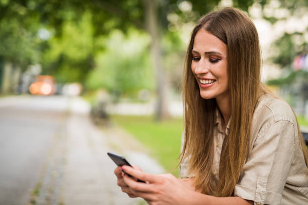 istock Happy young woman using phone outdoors. in the public park. 1166504972