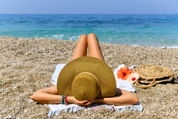 istock Woman in hat lying on beach. 1166504984