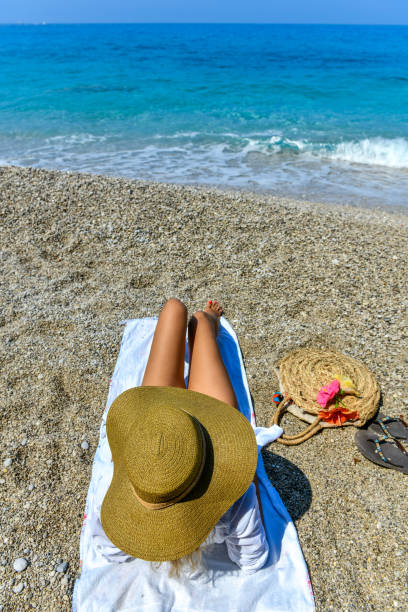 istock Woman in hat lying on beach. 1166508921