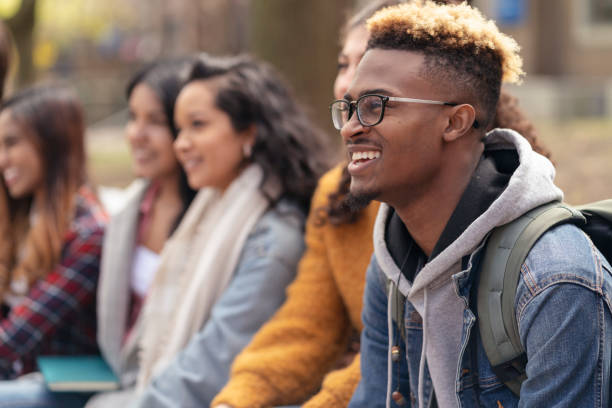 multiethnische gruppe von universitätsstudenten entspannt sich draußen - friendship young adult group of people multi ethnic group stock-fotos und bilder