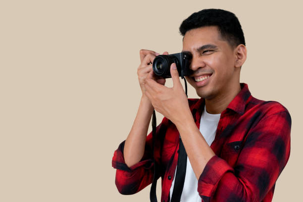 istock close up traveler hipster man smiling and using camera mirrorless for take photo isolated with clipping path on cream color background for summer season and travel destination advertisement concept 1166511357