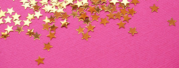 istock Golden stars glitter on pink background 1166511935
